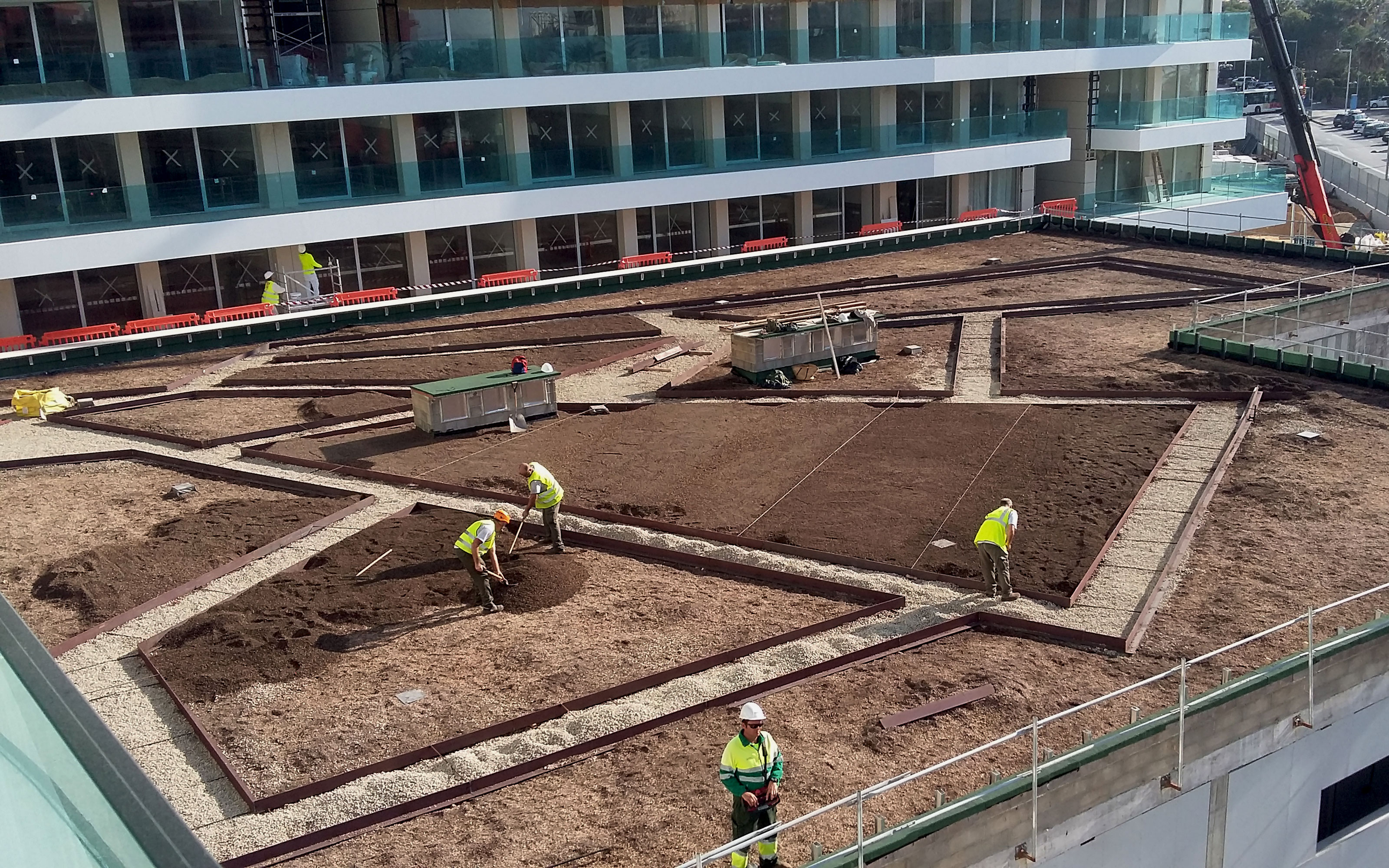 The areas prepared for planting are separated by gravel paths.  Green roof during installation